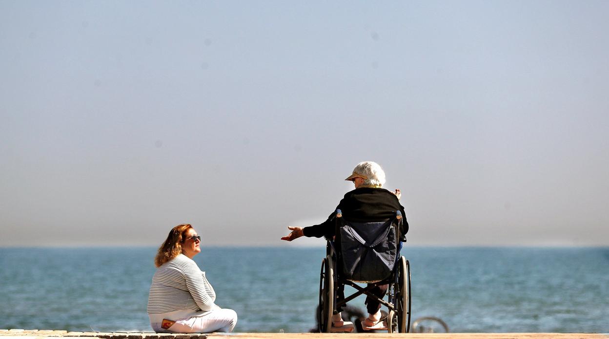 Dos mujeres conversan a orillas del mar mientras disfrutan del sol el pasado febrero