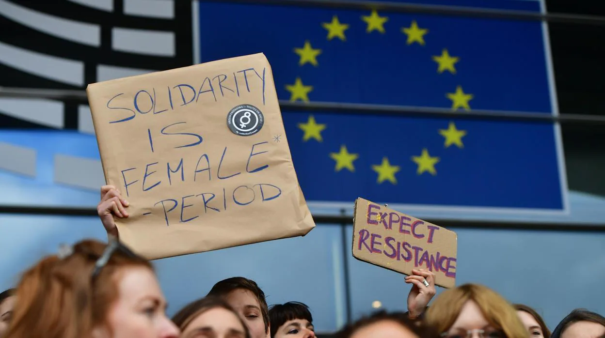 Eurodiputadas del Parlamento Europeo y su personal sostienen una pancarta que dice "Estamos en huelga" mientras protestan en la entrada principal del Parlamento Europeo para conmemorar el Día Internacional de la Mujer en Bruselas el 8 de marzo de 2019