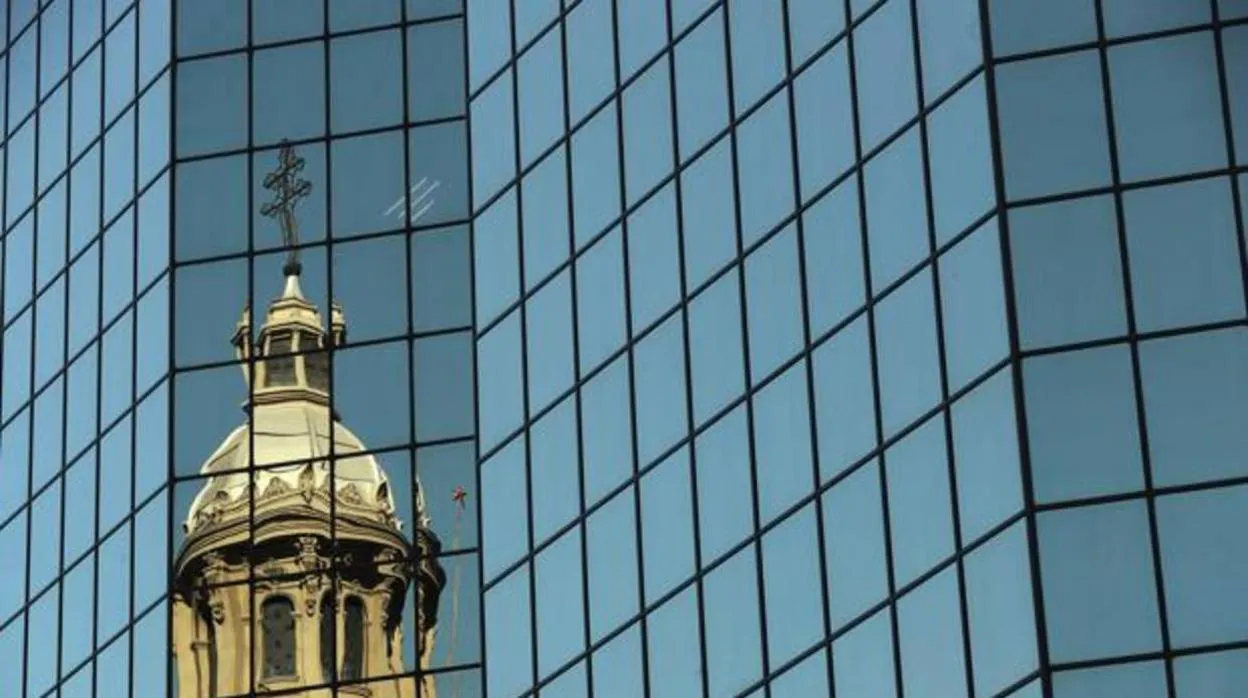 ista de una de la cúpulas de la catedral de Santiago reflejada en un edificio