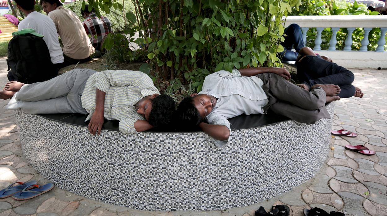 Dos viajeros descansan a la sombra en Calcuta, India
