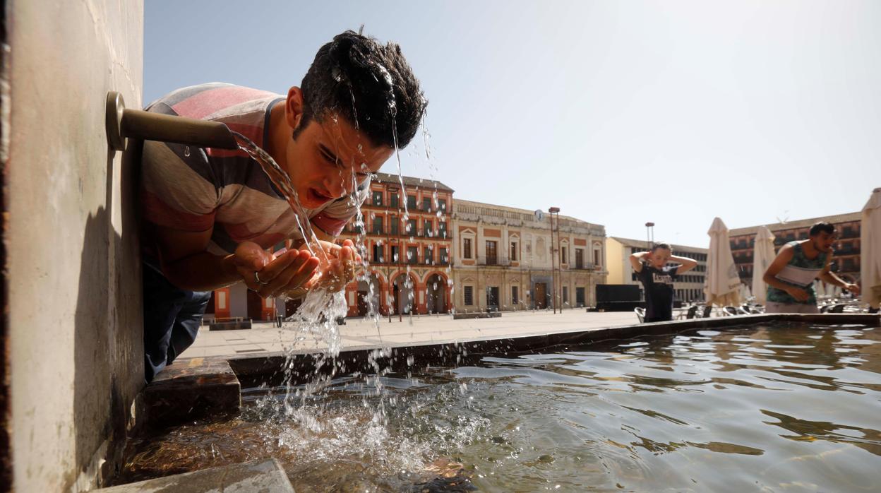 Un joven se refresca en la fuente del patio de los naranjos de la mezquita catedral de Córdoba