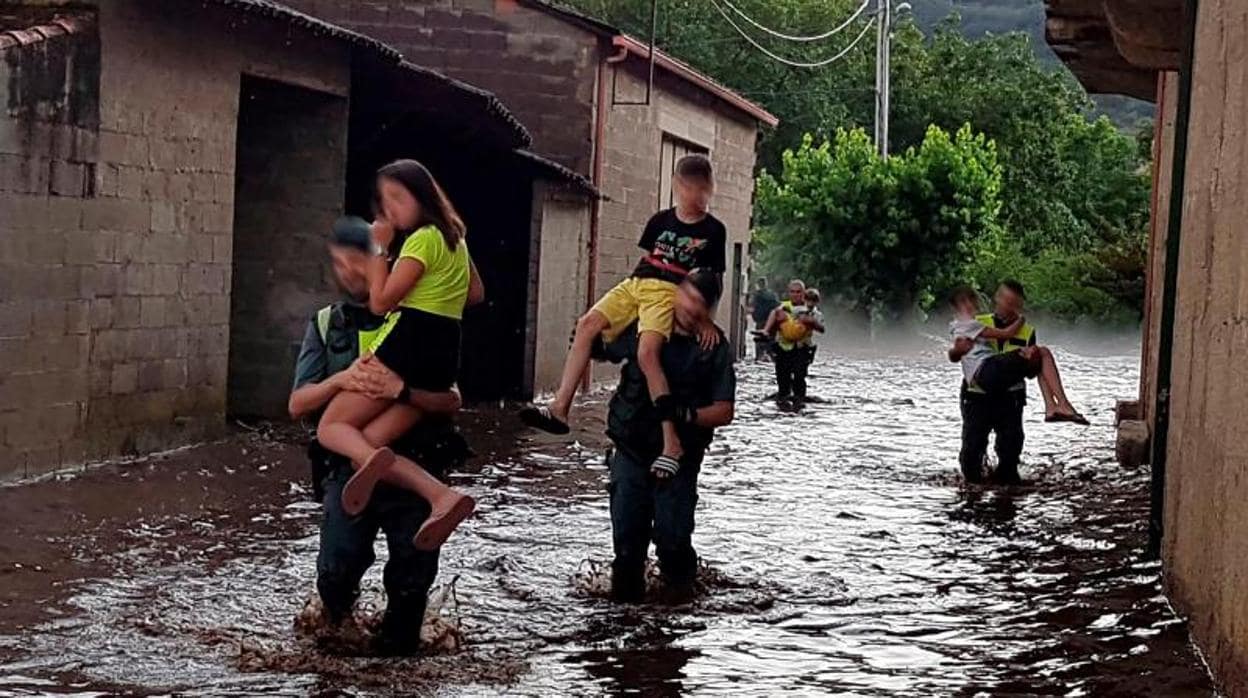 Agentes de la Guardia Civil trasladan a varios niños de Infesta, en Monterrei (Ourense), tras la riada