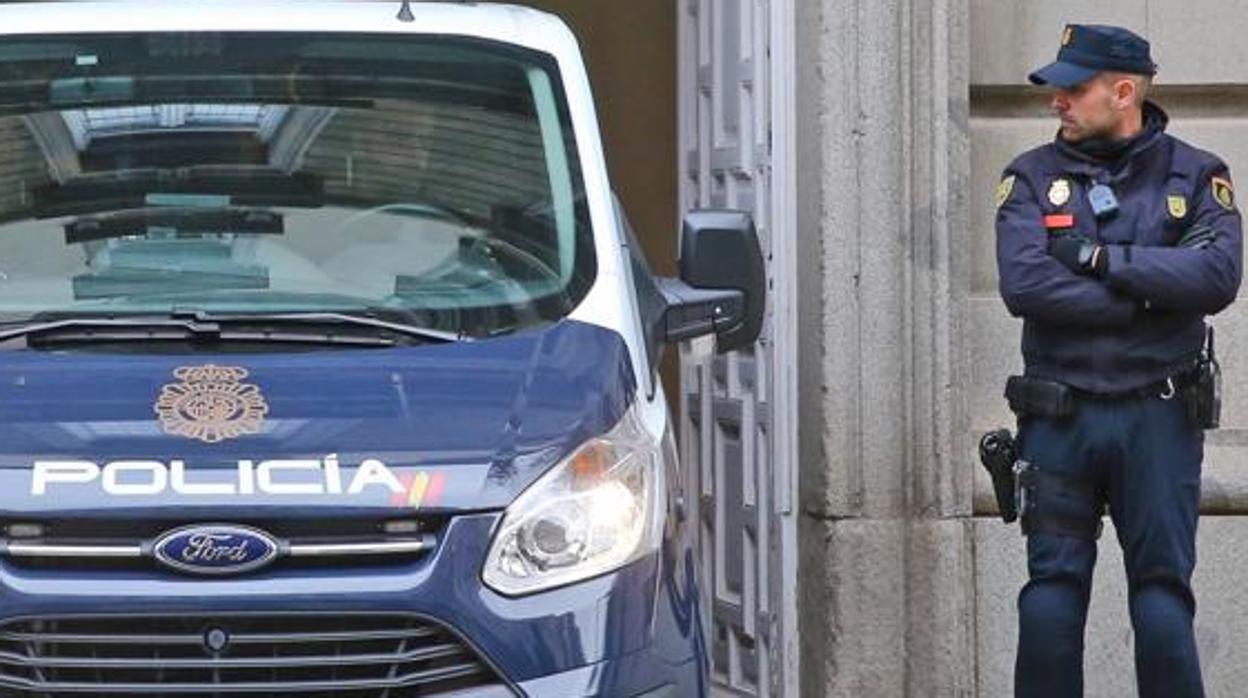 Imagen de un coche y un guardia de la Policía Nacional