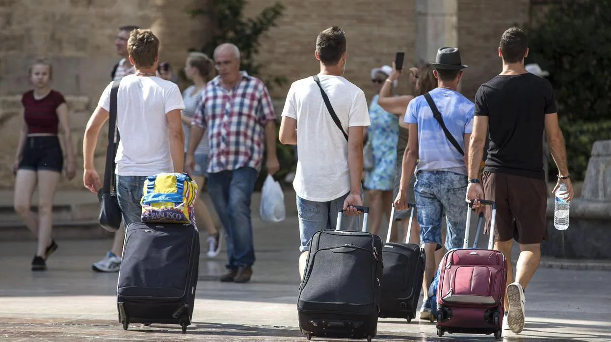 Un grupo de turistas camina por las calles de Valencia