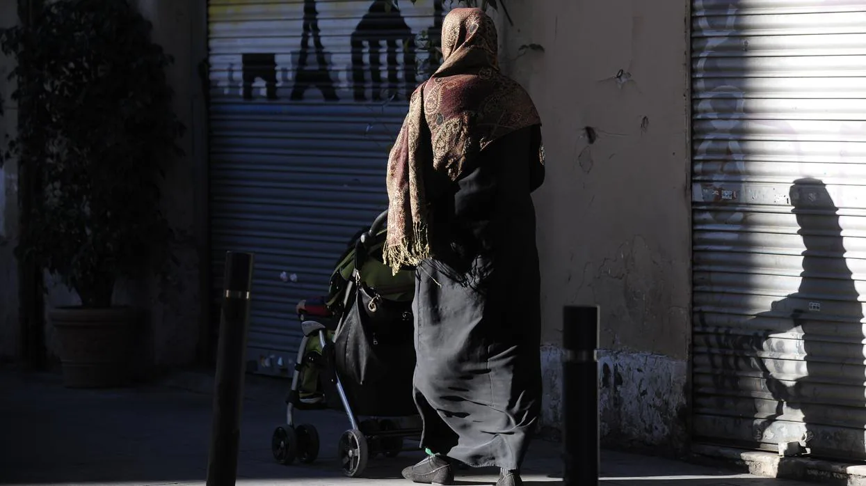 Una mujer camina por la calle vistiendo el velo islámico