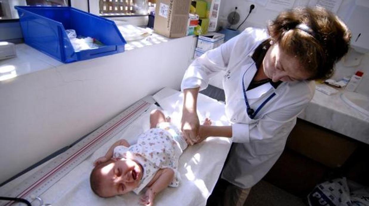 Una profesional sanitaria vacuna a un bebé