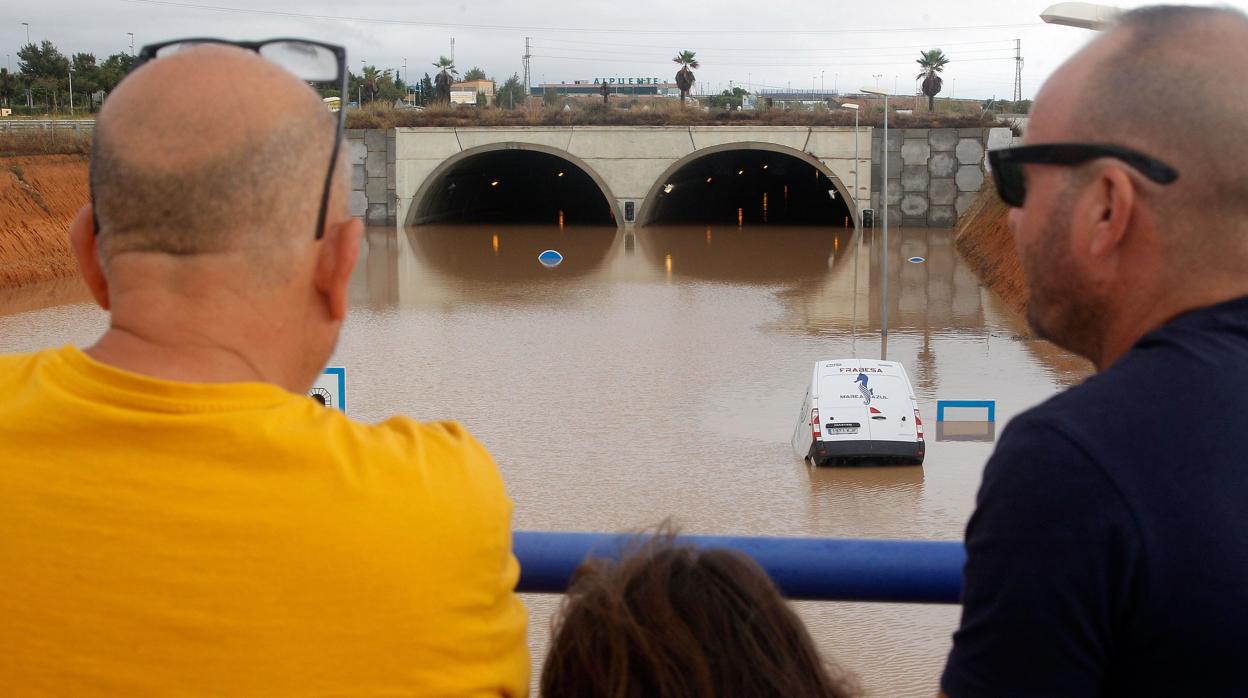 Varias personas observan la salida del túnel de la AP-7, que ha quedado inundado por la gota fría