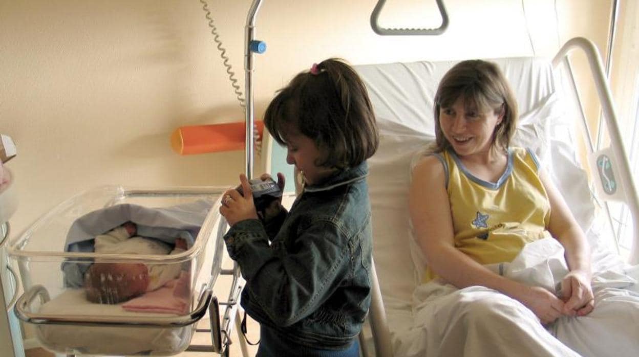 Un bebé recién nacido junto a su madre y su hermana en un hospital francés