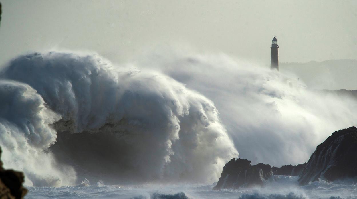 Una ola rompe en el faro de la isla de Mouro hoy domingo en Santander