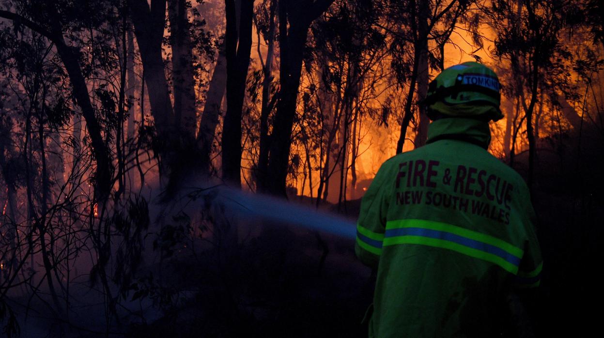 Un bombero trata de sofocar uno de los fuegos que arden estos días en Australia