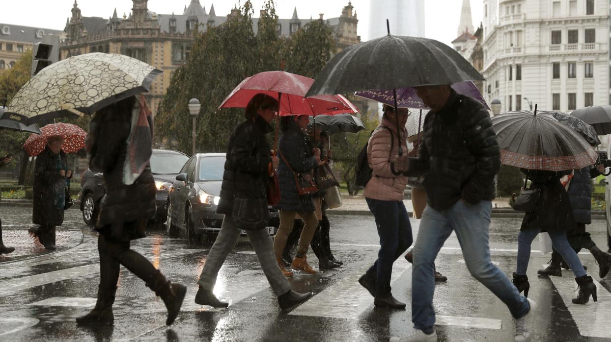 Personas se protegen con paraguas en Bilbao