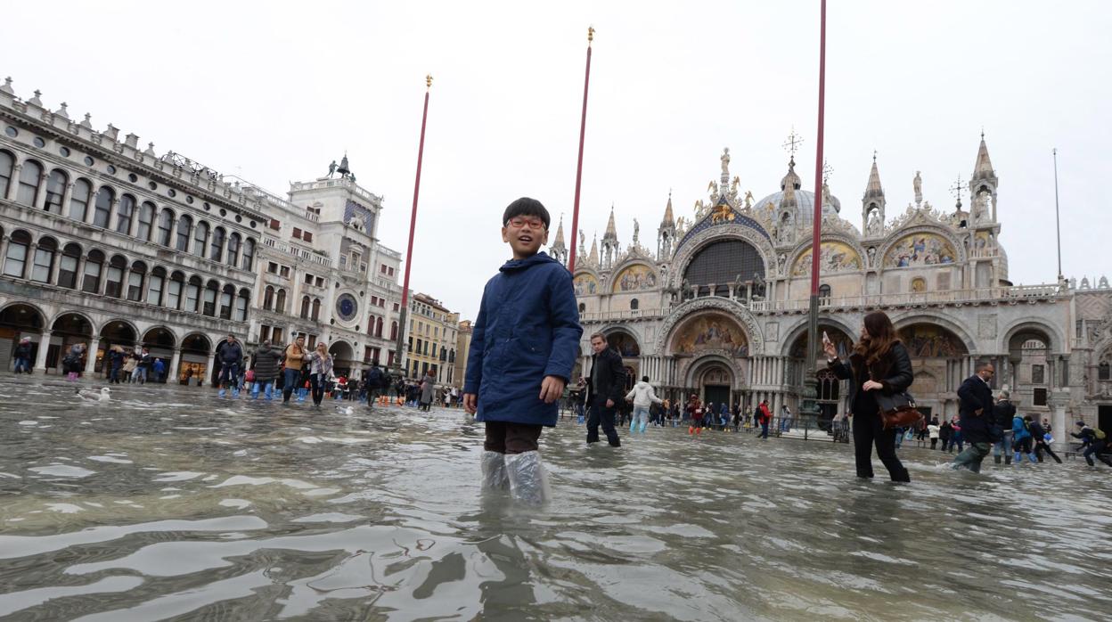 Un niño pasea por la inundada Plaza de San Marcos en Venecia (Italia)