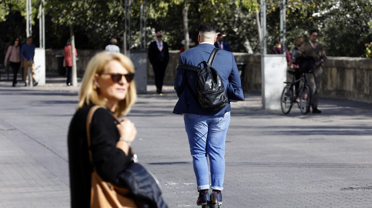 Gente circulando en patinete eléctrico por una zona peatonal de Córdoba: la multa será de 200 euros, a partir e ahora, con «matices» dependiendo de las ordenanzas municipales