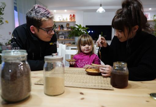 Sobre una mesa reciclada, Khloe merienda tostada con miel ecológica de productores locales