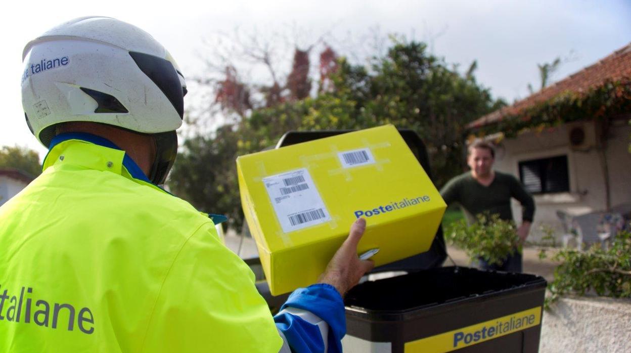 Un cartero del servicio postal de Italia entrega un paquete