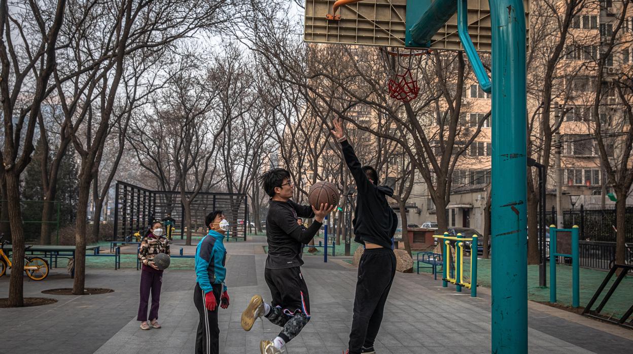 Un grupo de chicos practicando baloncesto en el Pekín del coronavirus
