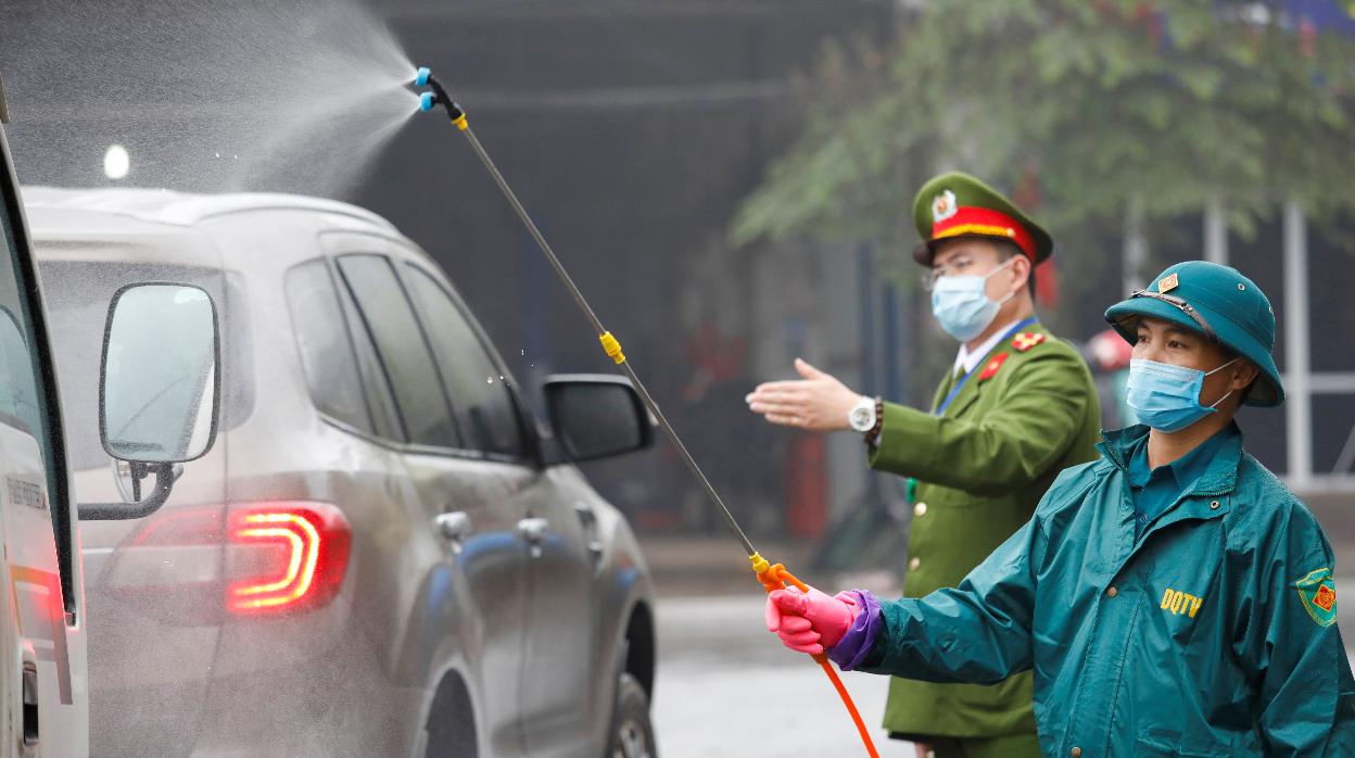Un equipo anticoronavirus desinfecta coches en Vietnam