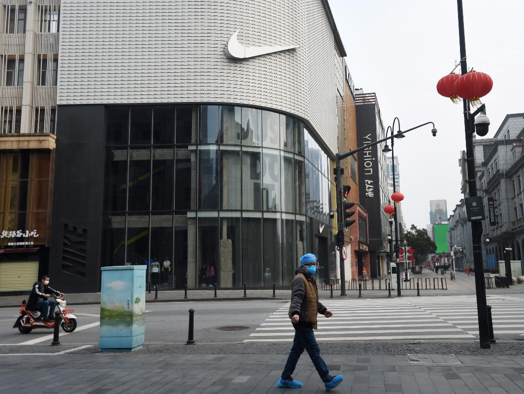 Un transeúnte en una calle desierta de Wuhan