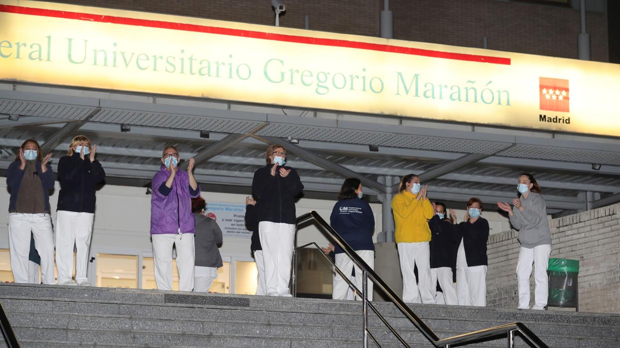 Personal del Hospital Gregorio Marañón salen al exterior para devolver los aplausos que los vecinos les dedican como cada tarde a las 20:00 por su indispensable labor a la hora de frenar la propagación del coronavirus, este jueves en Madrid