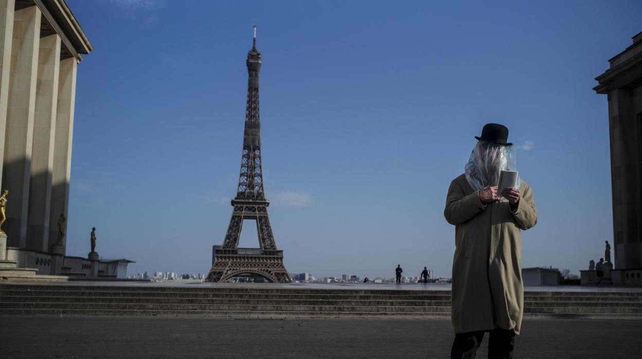 Un hombre se cubre con una bolsa de plástico, ayer, en París