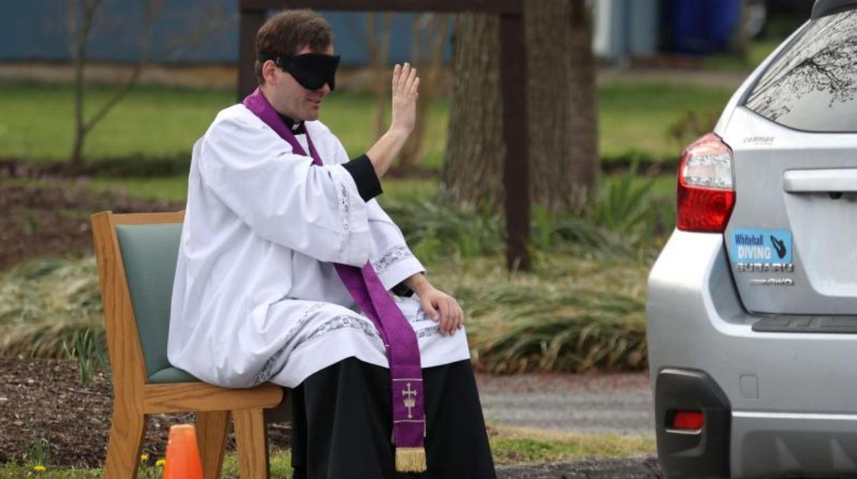 Scott Holmer ofrece el sacramento de la confesión a un feligrés en su coche en Bowie, Maryland.