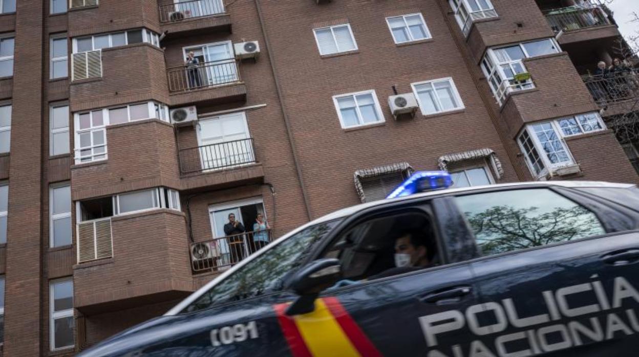 Un coche de Policía junto a un bloque de viviendas