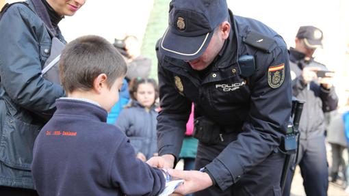 Un Policía coloca una pulsera a un niño