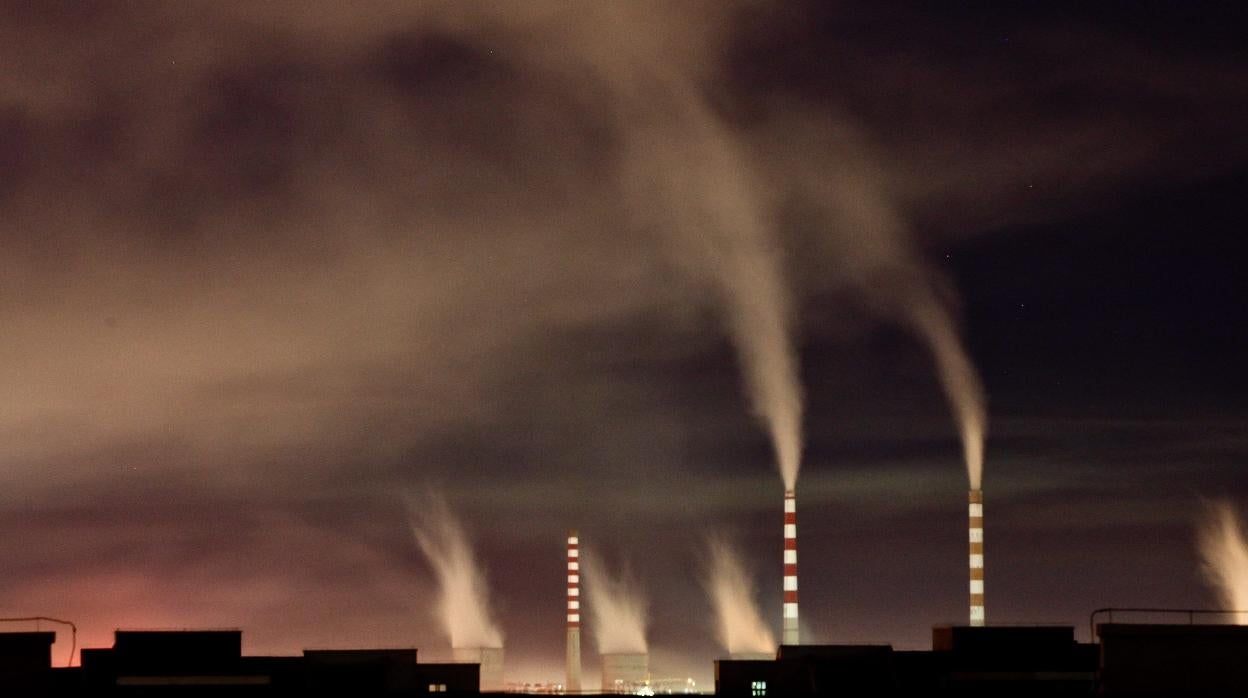 Chimeneas de una planta de energía de carbón emiten humo durante la noche