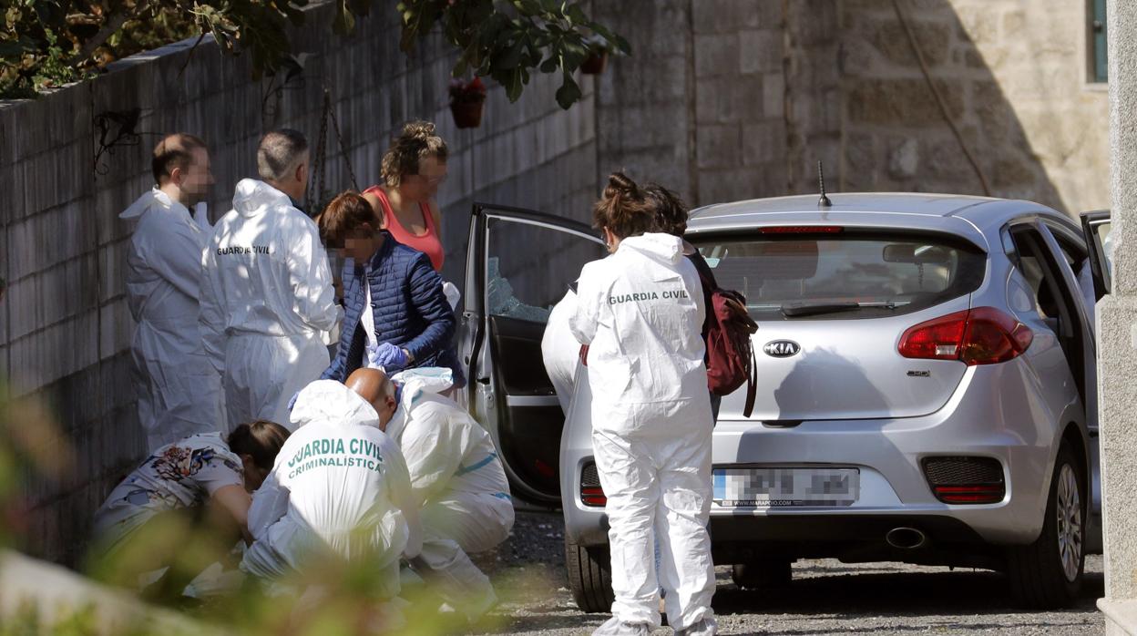 Agentes de la Policía Judicial en la vivienda donde se cometió este lunes un triple crimen en la parroquia de Cordeiro de Valga (Pontevedra), donde la Guardia Civil ha detenido a un hombre que mató a tiros a su expareja, a su exsuegra y a su excuñada y después se entregó a las autoridades en Ames