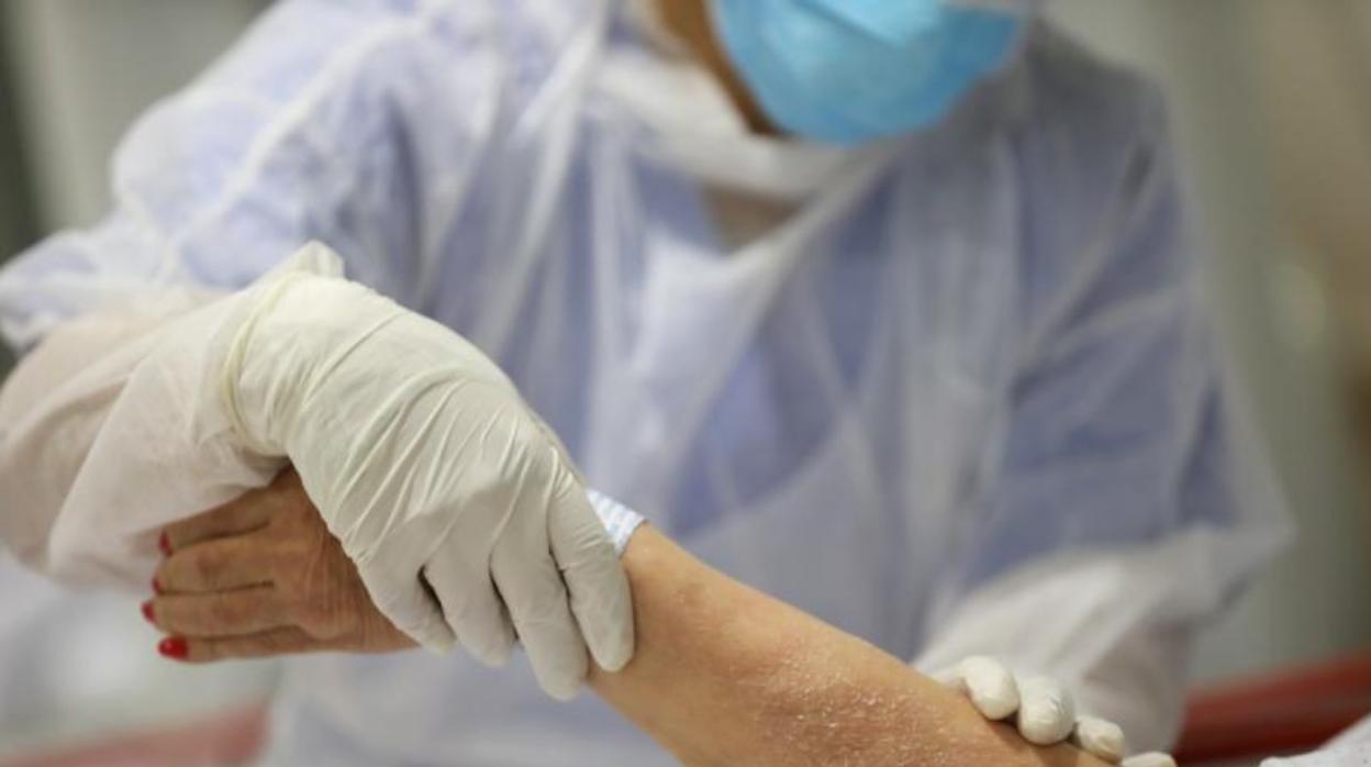 Una sanitaria trata a una paciente en la sala de emergencias de un hospital