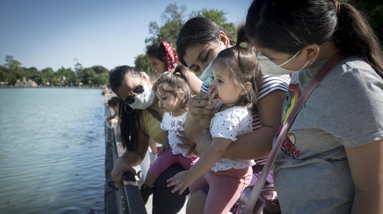 Una niña se acerca la mano a la boca en el parque del Retiro de Madrid