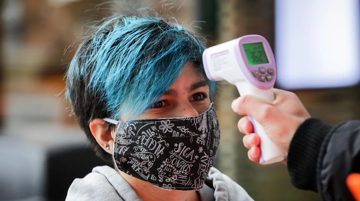 Un funcionario le toma la temperatura a una mujer en Uruguay