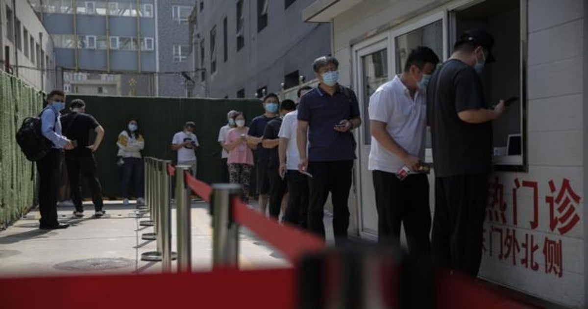 Personas usando la mascarilla mientras hacen una cola para hacerse una prueba del Covid en el Beijing Puren Hospital