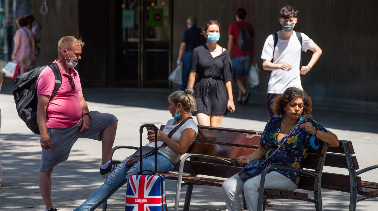 Una pareja de turistas británicos descansan en un banco de las Ramblas este lunes