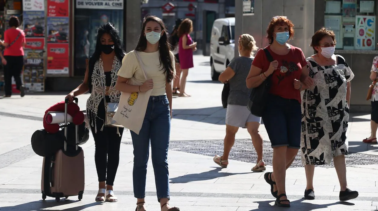 Peatones se protegen con mascarillas del coronavirus