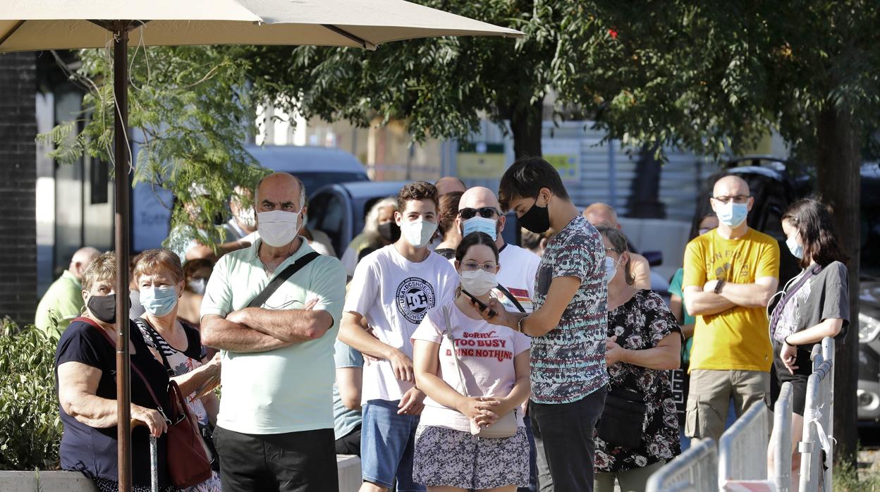 Vecinos del barrio barcelonés de Torre Baró, a la espera de someterse a las pruebas PCR