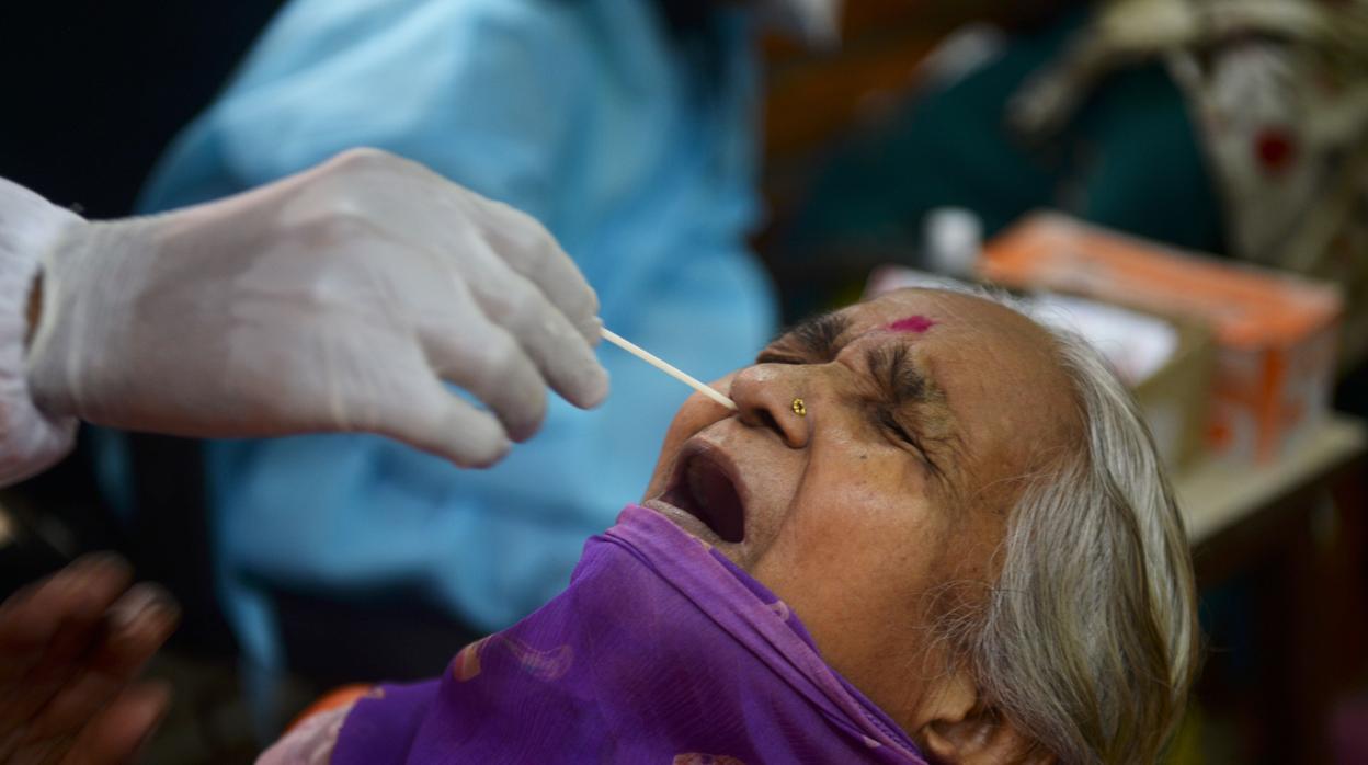 Un sanitario realiza una prueba del coronavirus a una anciana en Bombay (India)