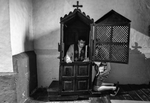 Mayo 2020: El padre Juan Jose Blanco se protege con una macarilla mientras imparte el sacramente de la confesión