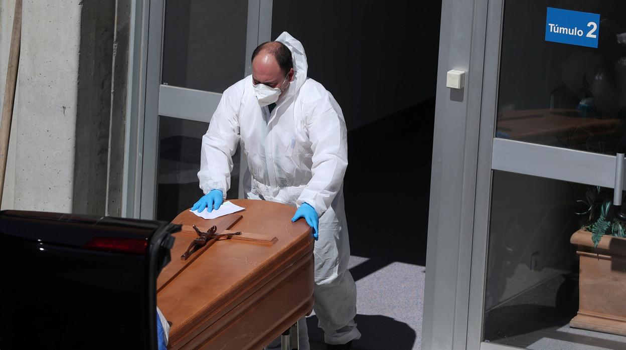 Un operario traslada un féretro en la morgue del Hospital Severo Ochoa de Madrid