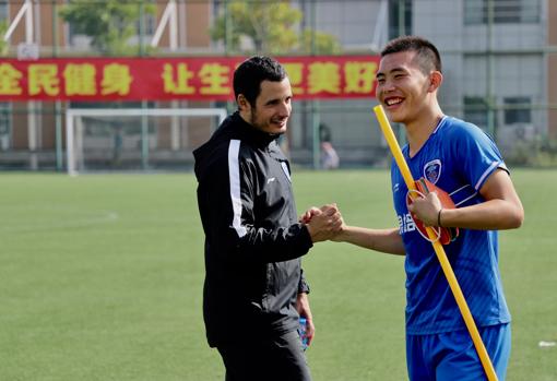 Eduardo San José, de Barcelona, bromeando con uno de los jugadores chinos durante los entrenamientos.