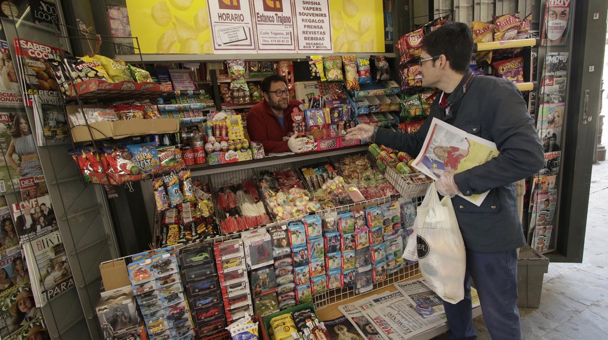 Kiosko de prensa en la calle Laraña de Sevilla y lector de ABC