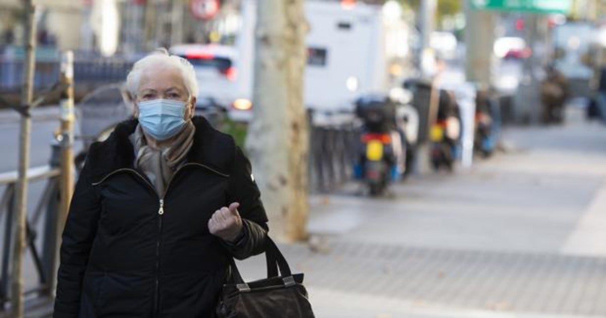 Una mujer con mascarilla por la calle