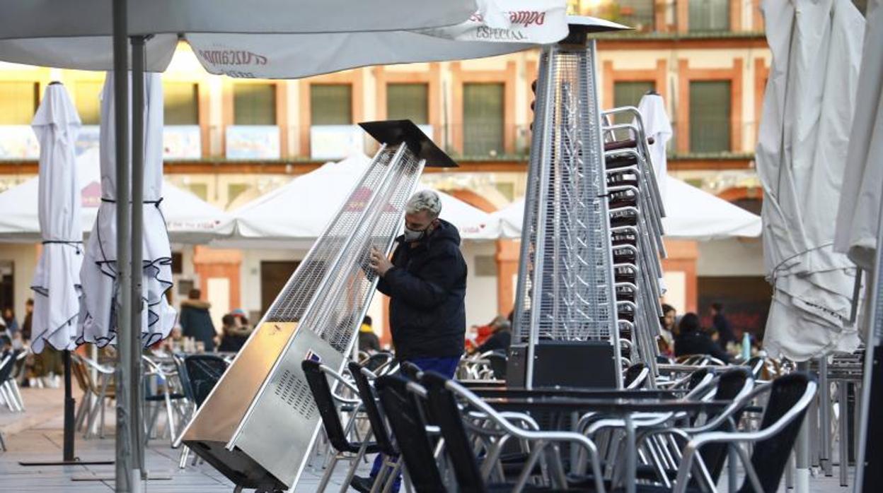 Un trabajador recoge el mobiliario de la terraza de un restaurante