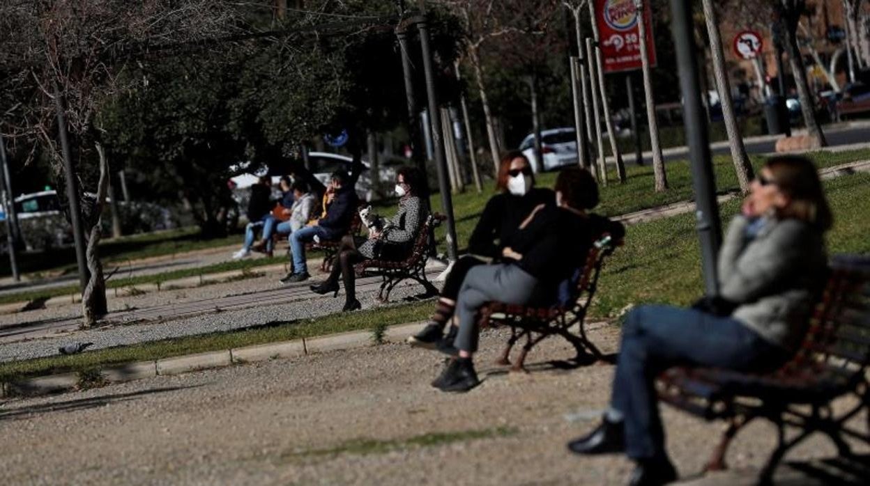 Varias personas disfrutan de las temperaturas cercanas a los veinte grados alcanzadas en Valencia