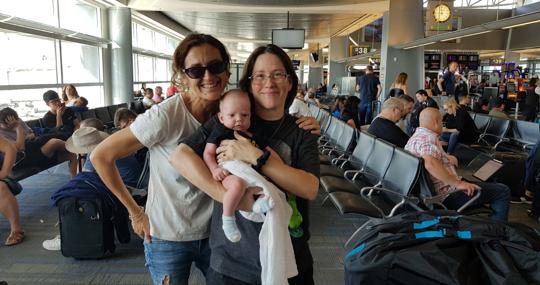 Lola, junto a la gestante y el bebé, en el aeropuerto antes de volver a España