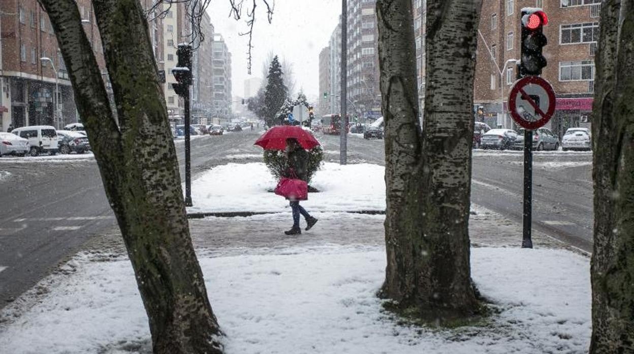 Una mujer con un paraguas camina por una vía nevada en Burgos, Castilla y León (España), a 8 de marzo de 2021