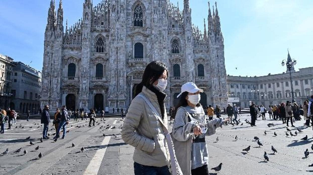 Dos mujeres con máscarilla caminan por la «Piazza del Duomo», en Milán