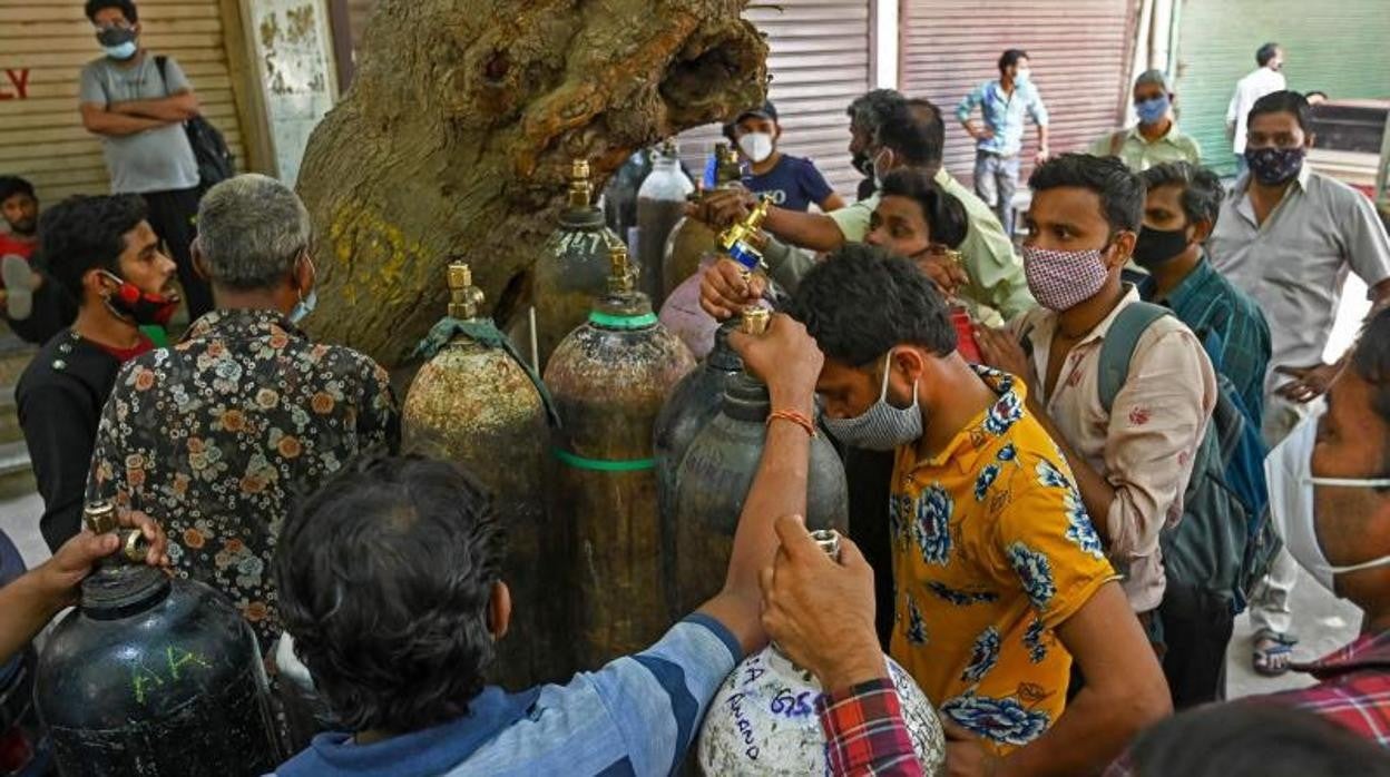 Personas esperan para volver a llenar sus cilindros de oxígeno médico para los pacientes con coronavirus Covid-19 bajo cuarentena domiciliaria