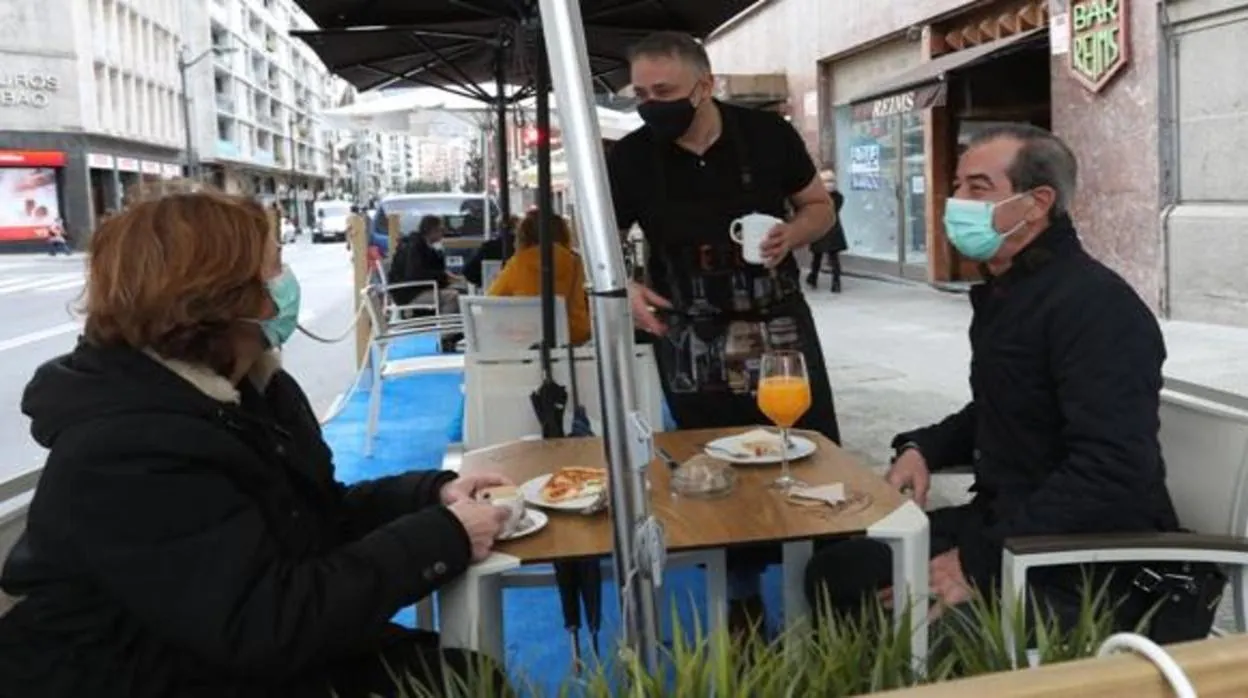 Varios clientes desayunan en la terraza de un bar el primer día de reapertura de la hostelería en el País Vasco