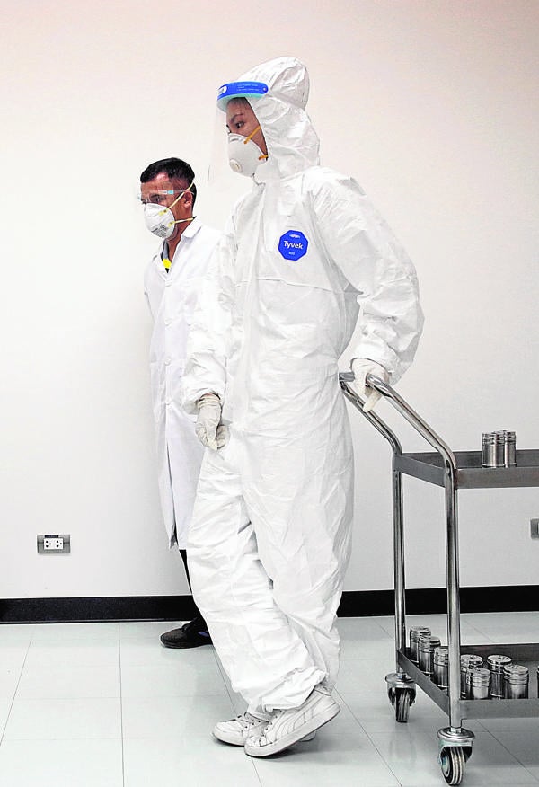 Entrenamiento de perros rastreadores. Funcionarios tailandeses observan a un perro labrador que se sienta tras detectar una infección por Covid en muestras de sudor humano, en el Hospital de Entrenamiento de Animales Pequeños, en la Universidad de Chulalongkorn, en Bangkok